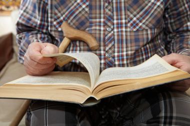 Yaşlı adam kitap okuyor.