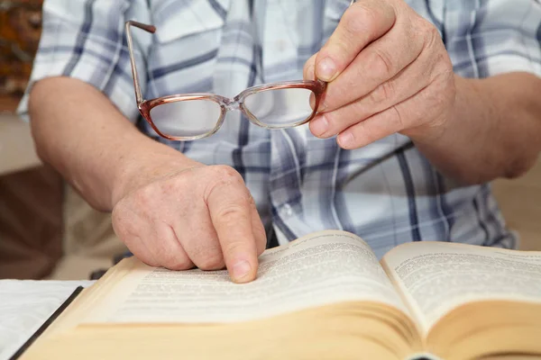 Ein älterer Mann mit Brille liest ein Buch — Stockfoto