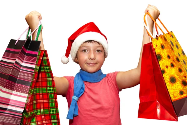 Petite fille en bonnet rouge avec des sacs à provisions. Noël — Photo