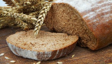 Taze ekmek ve ahşap tahta üzerinde olgun buğday