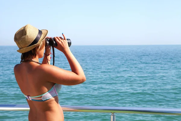 Ung kvinna med kikare och havet — Stockfoto