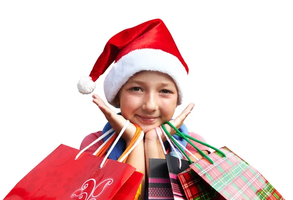 在与购物袋顶红色的帽子的小女孩。圣诞节 — 图库照片