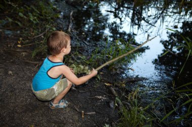 Küçük çocuk bir nehirde balık tutma