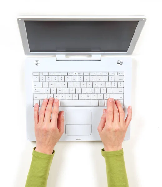 Handen in groene jas en witte laptop — Stockfoto