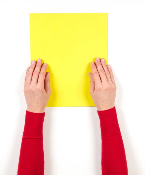 Руки и желтая бумага на столе — стоковое фото