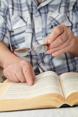 Yaşlı bir adam gözlüklü bir kitap okuma