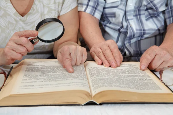 Ein älteres Ehepaar liest ein Buch — Stockfoto