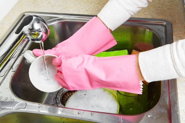 Hands washing dishes with running water from faucet — Stock Photo, Image