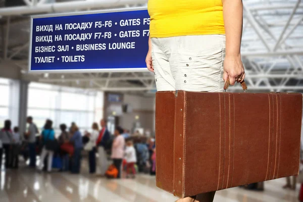 Woman with a suitcase is standing in the airport hall — Stock Photo, Image