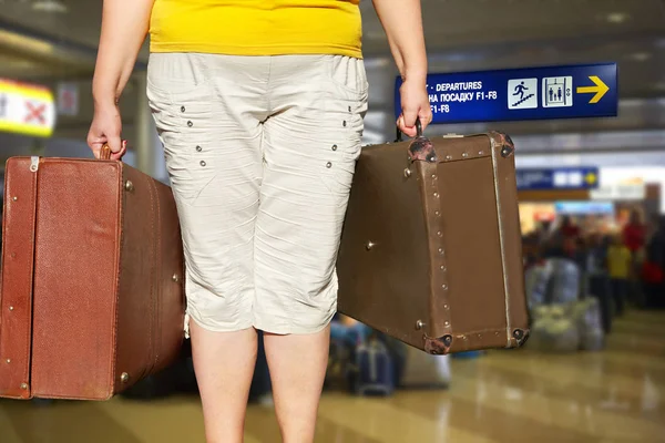 Woman with a suitcase is standing in the airport hall — Stock Photo, Image