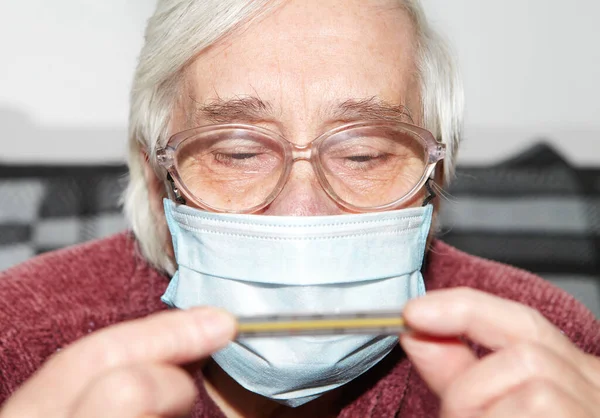 의료용 마스크를 나이든 전염병과 온도계 — 스톡 사진