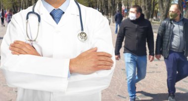 Doktor ve tıbbi maskeli insanlar salgın sırasında bir şehir caddesinde. Znamenka Şehri, Ukrayna, 12 Nisan 2020