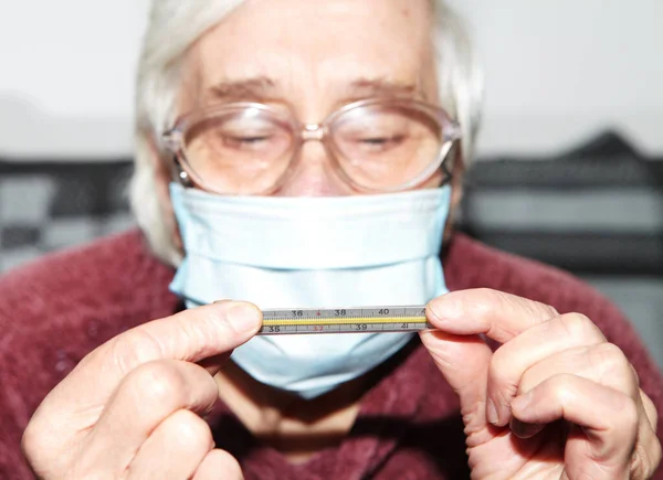 의료용 마스크를 나이든 전염병과 온도계 — 스톡 사진