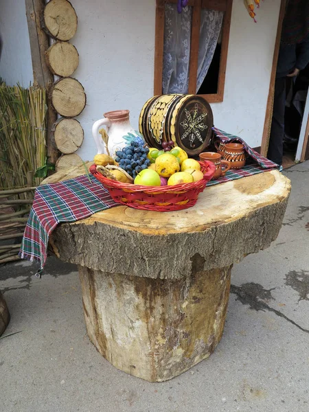 Tisch aus Baumstämmen mit Obstkorb und Weinfass — Stockfoto
