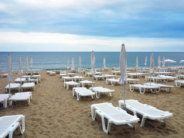 Sillas de playa y sombrilla en la arena cerca del mar, cielo azul — Foto de Stock