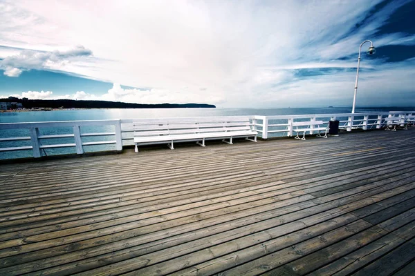 Banco blanco en muelle de madera en Sopot, Polonia . — Foto de Stock