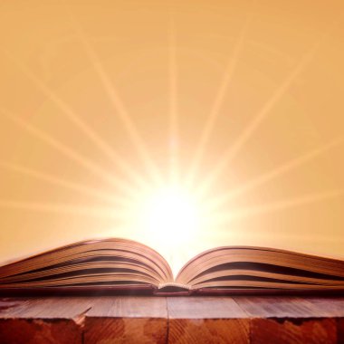 Tahta masanın üzerinde açık bir kitap.