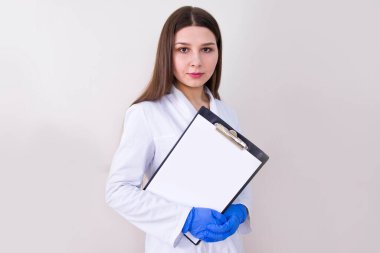 Koruyucu eldiven takan ve not tutan bir kadın doktor. Bedava fotokopi. Covid-19 konsepti.