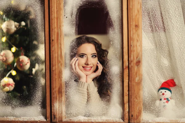 Felice ragazza allegra guardando attraverso la finestra congelata — Foto Stock