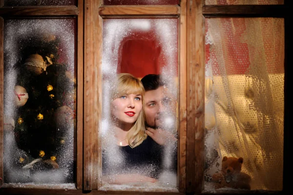 Felice allegro uomo e donna guardando attraverso la finestra congelata — Foto Stock
