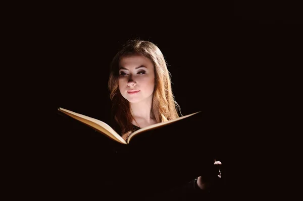 Портрет молодого студента, читающего книгу на черном фоне — стоковое фото