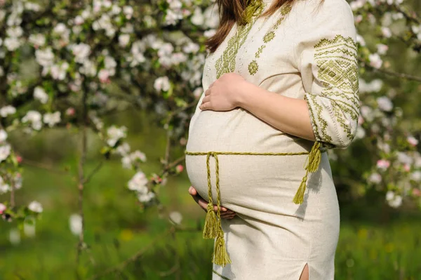 Беременная женщина в цветущем саду — стоковое фото