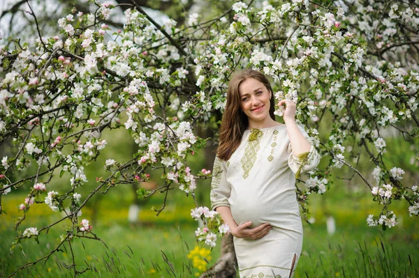 Gravid kvinna i blommande trädgård — Stockfoto