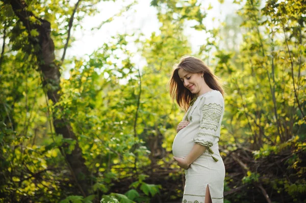 Gravid kvinna i blommande trädgård — Stockfoto