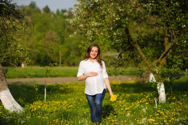 Těhotná žena v rozkvetlé zahradě — Stock fotografie