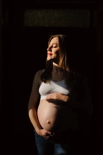 Милая беременная женщина трогает живот. — стоковое фото