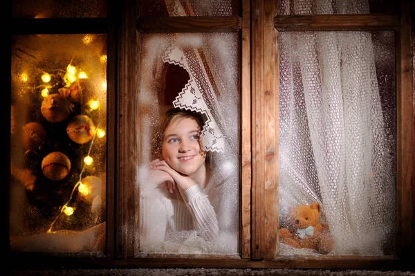 Ragazza guardando attraverso la finestra invernale — Foto Stock
