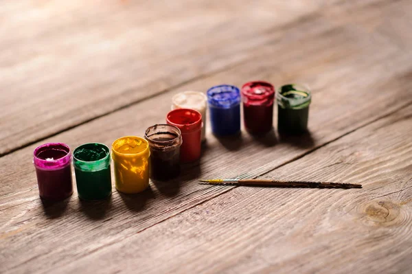 Pintura de diferentes colores en el fondo de madera — Foto de Stock