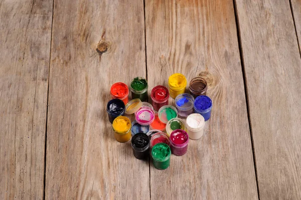 Pintura y pinceles que representan el corazón sobre el fondo de madera — Foto de Stock