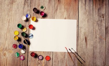 Kağıt, sulu boya, boya fırçası ve bazı sanat şeyler ahşap sekmesinde