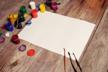 Kağıt, sulu boya, boya fırçası ve bazı sanat şeyler ahşap sekmesinde