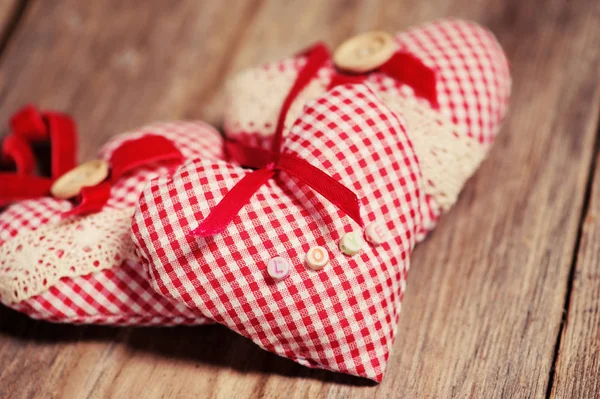 Corazones hechos de tela sobre un fondo de madera — Foto de Stock