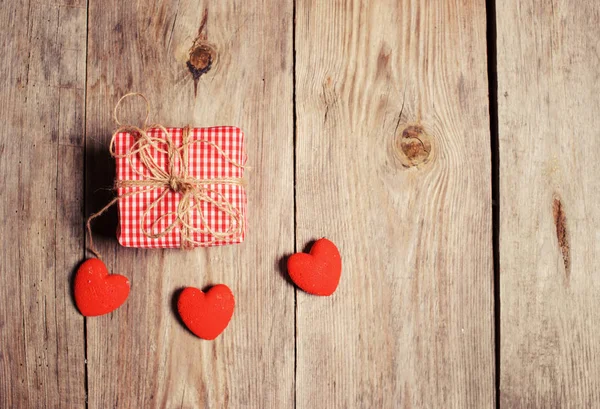 Сердце на деревянном фоне и подарочная коробка — стоковое фото