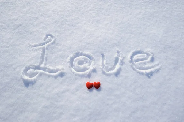 Palabra amor y corazón rojo en la nieve — Foto de Stock