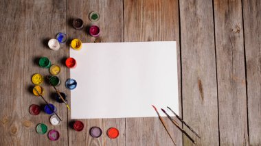 Kağıt, sulu boya, boya fırçası ve bazı sanat şeyler ahşap sekmesinde
