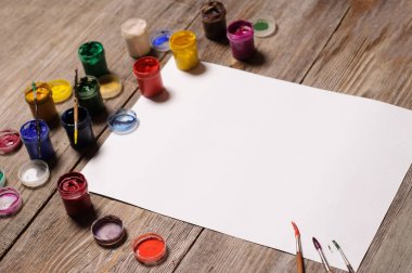 Kağıt, sulu boya, boya fırçası ve bazı sanat şeyler ahşap sekmesinde