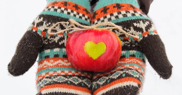 Manzana con corazón en las manos en invierno — Foto de Stock