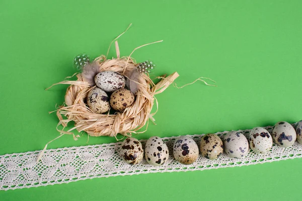 Yeşil zemin üzerine saman bir yuvada bıldırcın yumurtası — Stok fotoğraf
