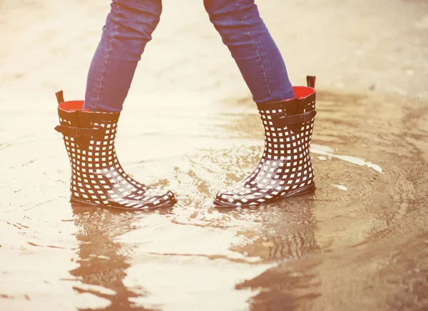 Pies en botas de goma en charco — Foto de Stock