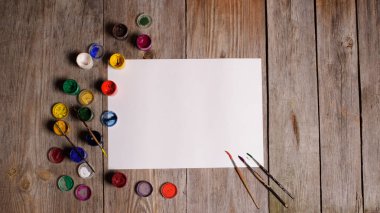 Kağıt, sulu boya, boya fırçası ve bazı sanat şeyler ahşap sekmesinde