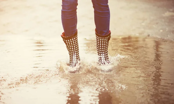 Pies en botas de goma en charco — Foto de Stock