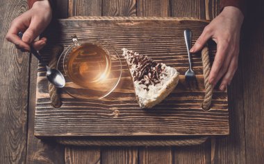 çay ve pasta ahşap masa üzerinde elle. Üstten Görünüm