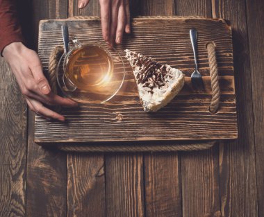 çay ve pasta ahşap masa üzerinde elle. Üstten Görünüm