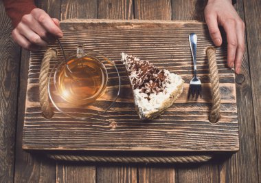 çay ve pasta ahşap masa üzerinde elle. Üstten Görünüm