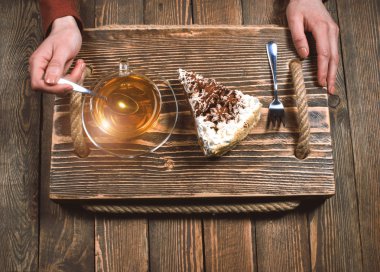 çay ve pasta ahşap masa üzerinde elle. Üstten Görünüm