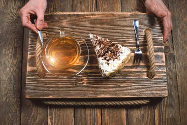 çay ve pasta ahşap masa üzerinde elle. Üstten Görünüm